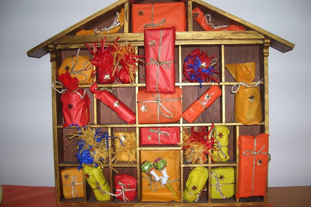 Adventskalender in Form eines Holzhauses mit 24 bunt verpackten Fächern