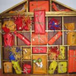 Adventskalender in Form eines Holzhauses mit 24 bunt verpackten Fächern