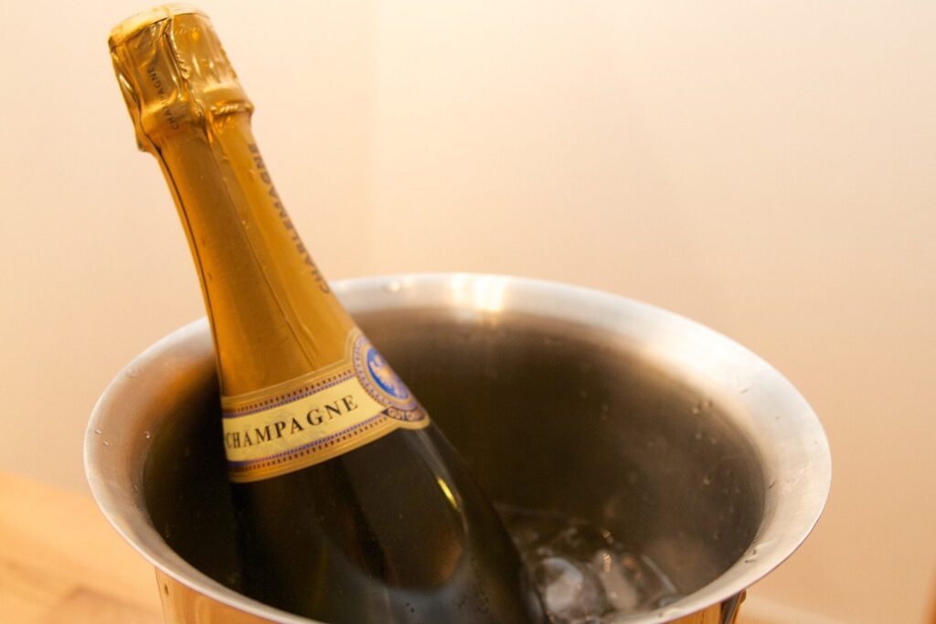 Champagnerflasche in einem Edelstahl-Sektkühler mit Eiswürfeln