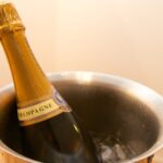 Champagnerflasche in einem Edelstahl-Sektkühler mit Eiswürfeln