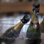 Mehrere Champagnerflaschen in einem Glaskübel mit Eiswürfeln